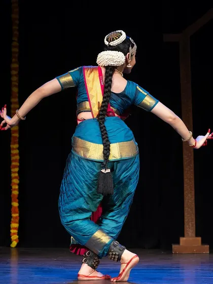 A view from the back during a performance at the Kanasu festival, highlighting the traditional hairstyle and costume details.
