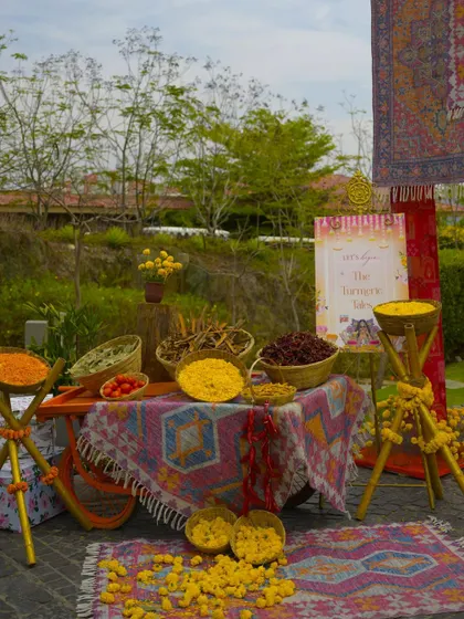 A traditional "haldi" station with various ingredients laid out on a colorful cart for the ceremony.