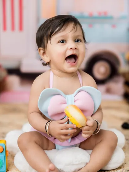 A big, happy expression from this little girl in her beach-themed setup.