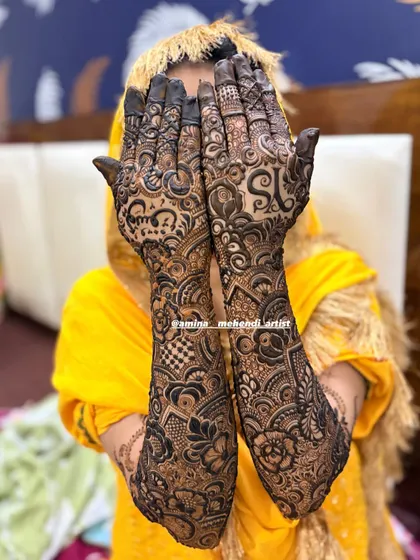 A gorgeous full-arm design with the initials 'YS' and the name 'Yusuf' in Urdu, framed by intricate checkerboard and floral patterns.