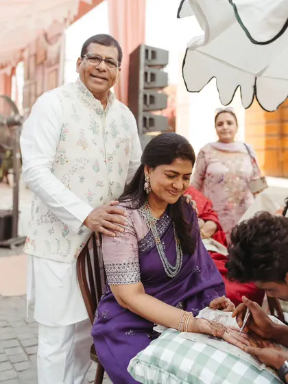 A candid moment of guests getting their henna done at the Mehendi, a cherished tradition and a time for connection.
