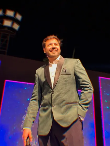 A confident and relaxed pose on stage, enjoying the vibrant atmosphere of the wedding celebration.
