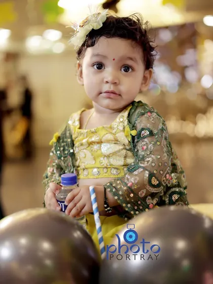 A curious portrait of the birthday girl, looking directly at the camera with her big, expressive eyes.