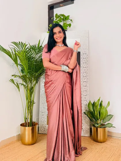 A dusty pink satin saree that is the definition of understated elegance. It's a versatile piece that can be styled for a farewell party, a cocktail event, or a romantic dinner.
