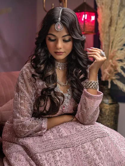 A graceful, introspective pose from a traditional wear photoshoot. This shot captures a quiet moment, showcasing the elegance of the outfit and the model's serene expression.