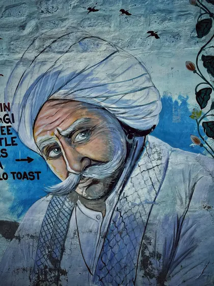 A beautiful wall painting of a Rajasthani man with a traditional turban and a grand mustache, captured while exploring the streets of Jodhpur.