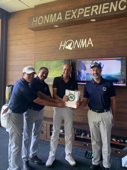 An Instructor Presenting an Award to a Participant: A moment of recognition at the Men's Golf Camp. One of our participants receives an award from our coaching staff for his excellent performance during the chipping and putting competitions.