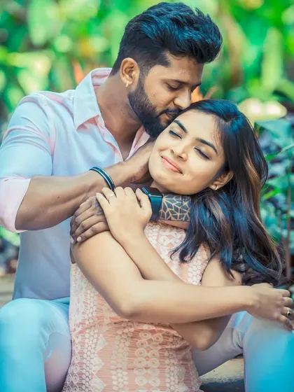 A tender moment captured as a man embraces his partner from behind, kissing her forehead. This close-up shot emphasizes connection and intimacy in our pre-wedding photography.