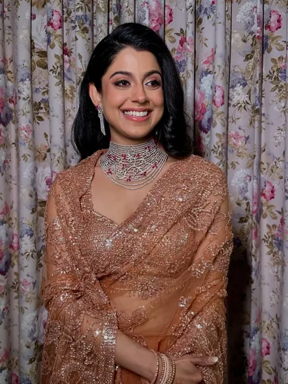 A beautiful portrait against a floral backdrop. Her soft yet striking glam is perfect for an elegant evening event.