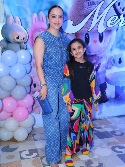 Mother and daughter pose in front of the Labubu backdrop. The detailed character art makes for a fantastic photo opportunity.