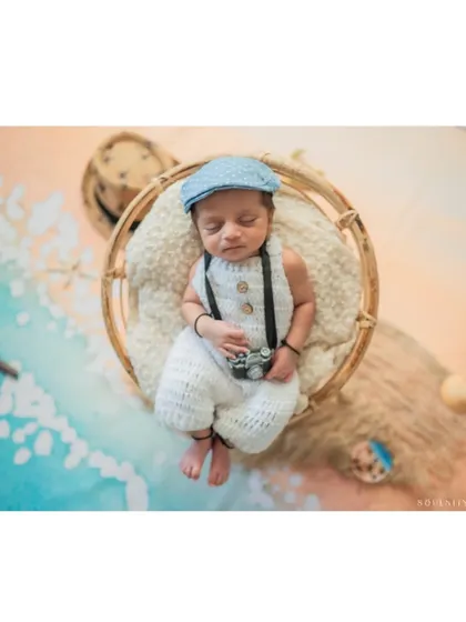 A peaceful, sleeping portrait of our little beachcomber, complete with a newsboy cap and a tiny camera.