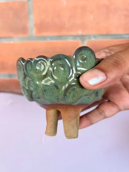 This tiny, whimsical sheep planter on three legs was hand-built by a student. The textured wool and sweet face are full of character.