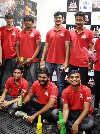 A group of students in red uniforms after a flair practice session, holding their practice bottles.