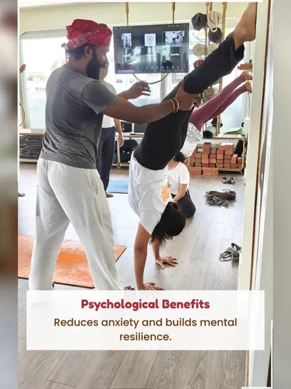 An instructor provides a hands-on adjustment for a student in a handstand variation, demonstrating the expert guidance and safety focus within our TTC.