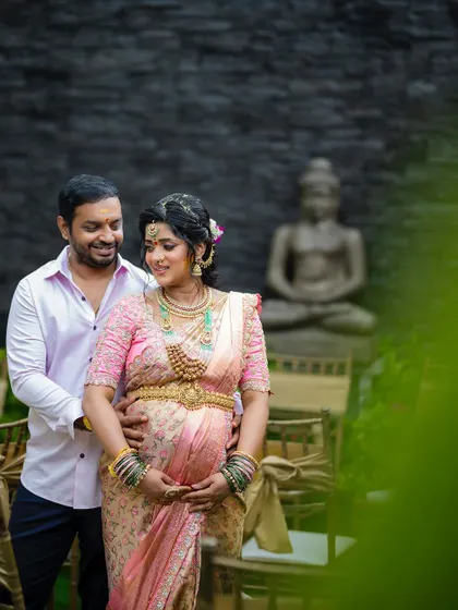 A loving portrait of the couple during their maternity shoot, with a beautiful Buddha statue in the background adding to the serene atmosphere.