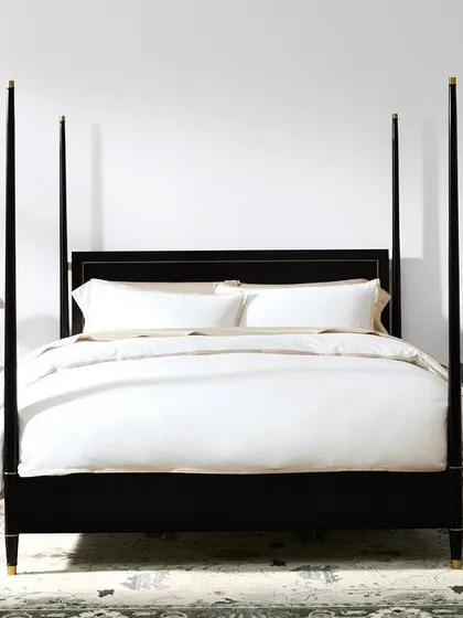 A frontal view of the Los Angeles four-poster bed, showcasing its pleasing proportions and the subtle elegance of the brass trim on the headboard.