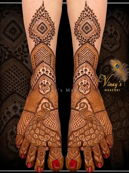 A classic bridal feet design with peacocks as the central motif. The feathers are detailed with fine lines, and the design extends to the ankles.