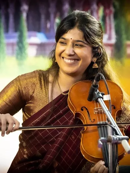 A beautiful, smiling shot of Apoorva Krishna during a traditional concert. Her joy in playing is contagious.