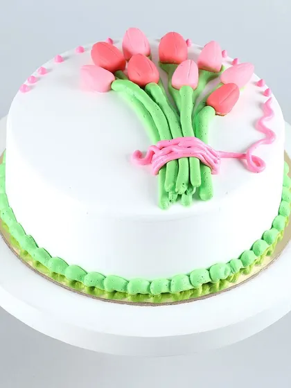 A cake that looks like a bouquet of flowers. This design features a beautifully piped bunch of pink tulips, making it an elegant and artistic choice for birthdays, anniversaries, or to simply say thank you.