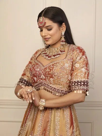 Every detail matters in a bridal look. Here, the bride is admiring her jewellery, with the makeup providing a flawless canvas that enhances her natural features.