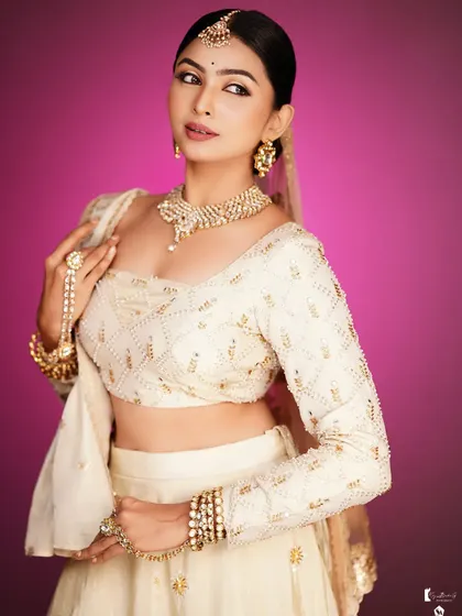 The side profile shows the elegant low bun and the delicate jewelry.
