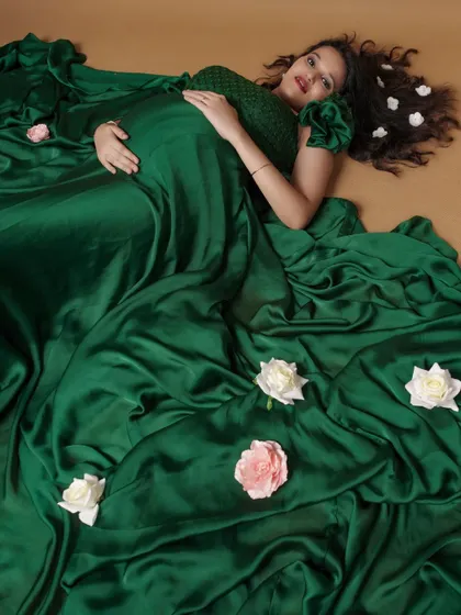 An overhead shot showing the beautiful spread of the green satin gown. We scattered some flowers to create a dreamy, artistic maternity portrait.