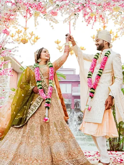 A joyful moment right after the Varmala ceremony. The couple dances under a canopy of cherry blossoms, their smiles reflecting the happiness of being officially united.