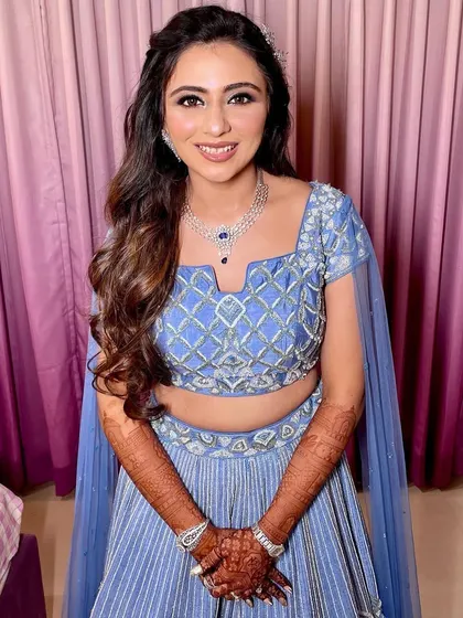 A full-length view of the bride, ready for her sangeet with her gorgeous outfit and wavy hair.