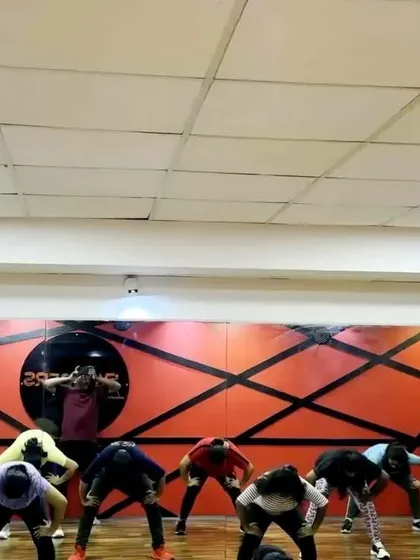 Students in the middle of a rehearsal, learning choreography. This behind the scenes view shows the process of building a complex stage performance.