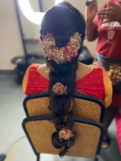 A complex pull-through braid adorned with a garland of dried flowers. This style is perfect for a rustic or bohemian bride, combining texture with natural elements.