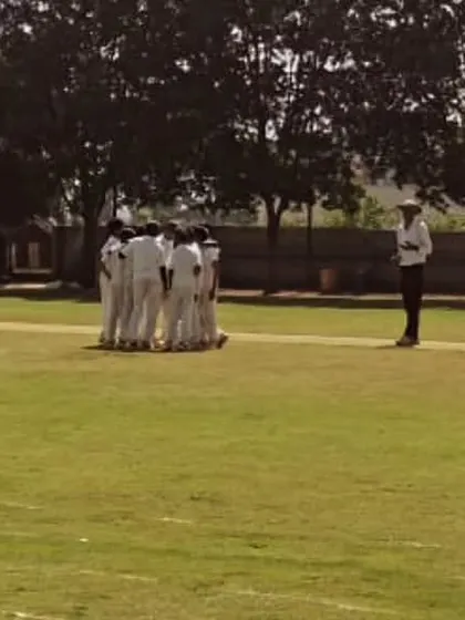 A team huddle on the field during a match, discussing strategy.