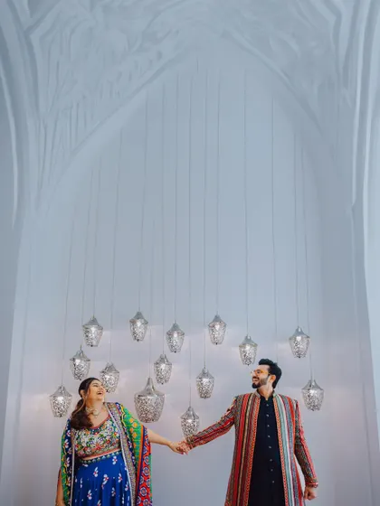 The couple shares a laugh under a stunning installation of hanging lights.