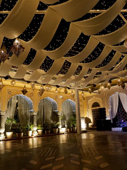 The dance floor ceiling, where soft white drapes are interwoven with fairy lights and traditional lamps to create a starry sky effect.