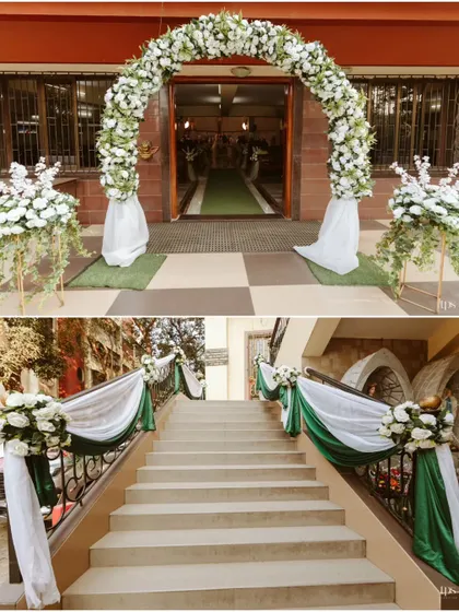 The entrance to Ryan and Ela's wedding was decorated with a classic white floral arch and simple, elegant drapes on the staircase, creating a sophisticated and welcoming first impression.