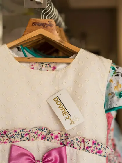 A close-up showing the delicate eyelet fabric of the bodice on this white and pink floral dress.