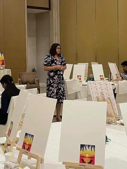 A glimpse of the setup for a corporate paint party. Each station is equipped with a canvas, easel, paints, and brushes, ready for a creative session.