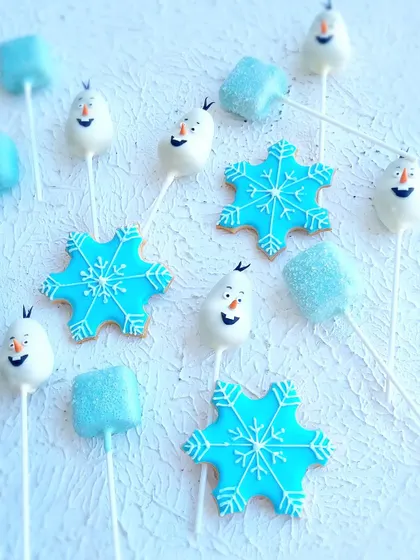 A close-up of the Frozen-themed treats, including Olaf cakepops and snowflake cookies.