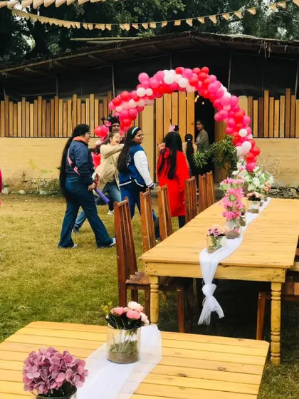 A balloon arch frames the entrance to our rustic event space, ready for a party to begin.