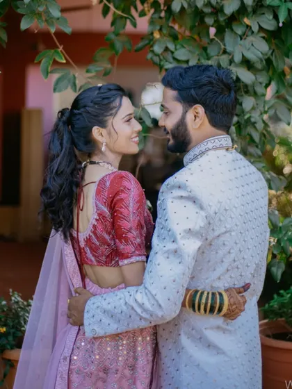 A sweet, candid moment between a couple during their engagement or pre-wedding event, captured in a natural outdoor setting.