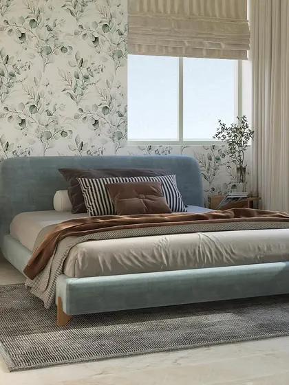 A minimalist bedroom design where simplicity meets class. The soft blue upholstered bed is set against a delicate, nature-inspired wallpaper, creating a light and airy feel.