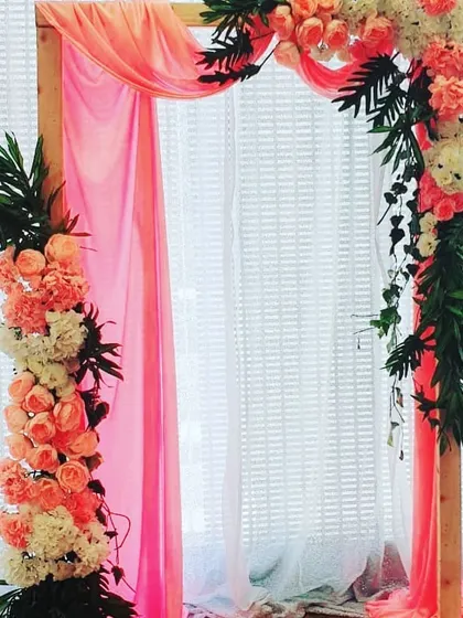Another view of the naming ceremony arch, showing how the floral arrangements and drapery create a beautiful frame. This versatile piece can be used as a photo booth or cradle backdrop.