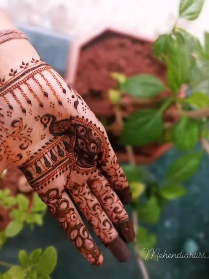A graceful peacock design on the palm, with delicate details on the fingers. This is a classic and beloved mehendi motif.