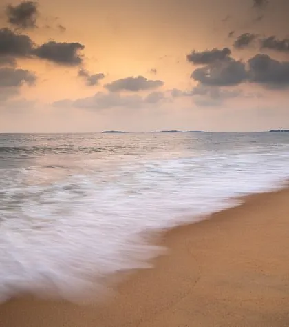 The gentle motion of the waves on the shore, captured with a slow shutter speed. This technique transforms the water into a soft, misty blanket.