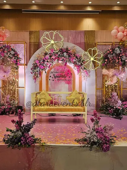 A full view of the glamorous stage for an Aqeeqah ceremony. The combination of pink, purple, and gold, along with florals and balloons, creates a truly grand and celebratory setting.