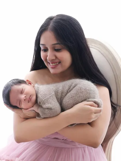 A close-up of a mother's adoring smile as she holds her sleeping newborn. This shot captures the pure joy and love that a new baby brings.