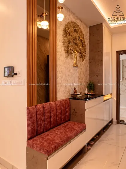 A closer look at the foyer seating, featuring a plush, channel-tufted cushion in a rich red velvet. The design combines practical shoe storage with a comfortable spot to pause when entering or leaving the home.