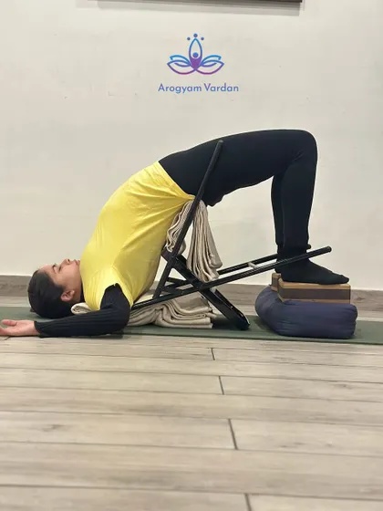 This complex setup for Chatushpadasana uses a chair, blocks, and blankets. It provides maximum support, allowing for a longer hold and a deeper, more restorative opening of the spine and chest.