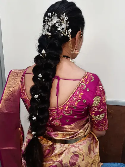 A voluminous braid accessorized with a beautiful silver floral clip. This style is perfect for receptions and parties.