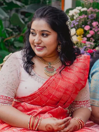 A happy, candid shot of a client ready for a party. Her makeup is natural and fresh, with soft curls and a pretty hair accessory.