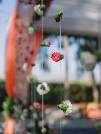 Delicate strings of carnations hang as a curtain, a simple yet beautiful way to create texture and division in a space.